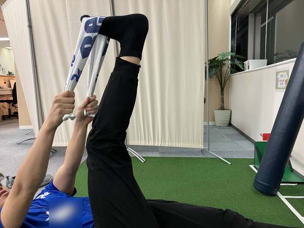 足裏にタオルを掛けて脚を上げる